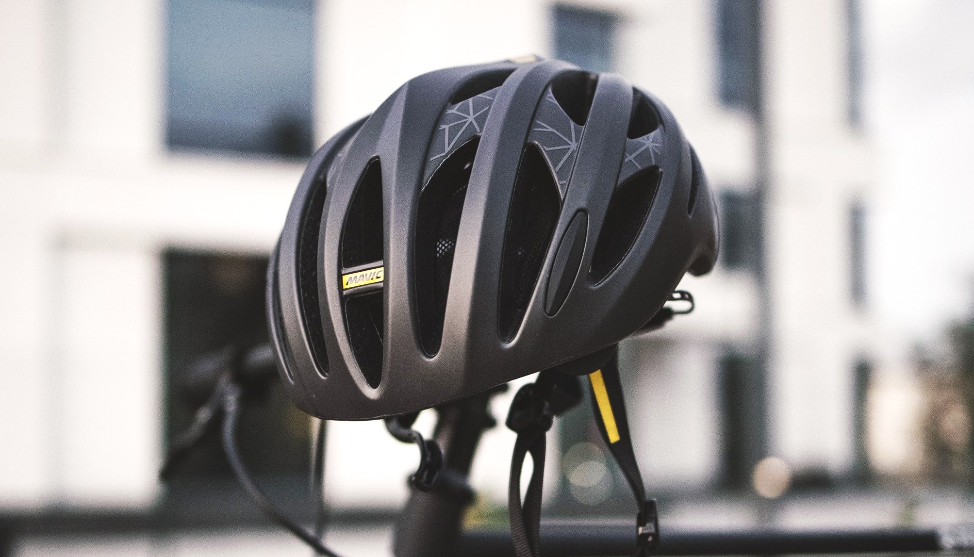 A closeup view of a bike helmet sitting atop a bike seat.