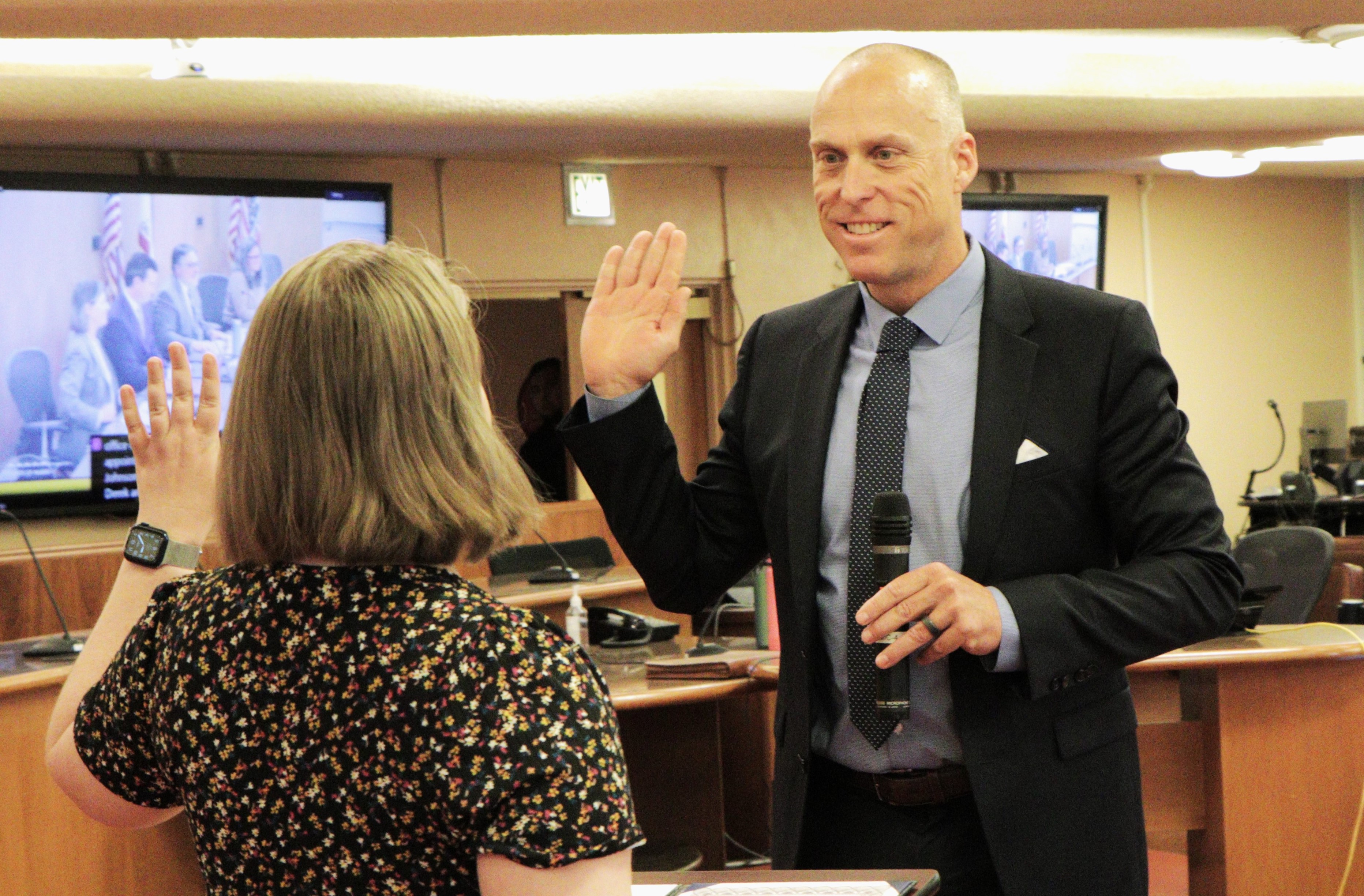 County Executive Derek Johnson, right, holds up his hand as he accepts the oath of office from Board Clerk Karla Kacmar.