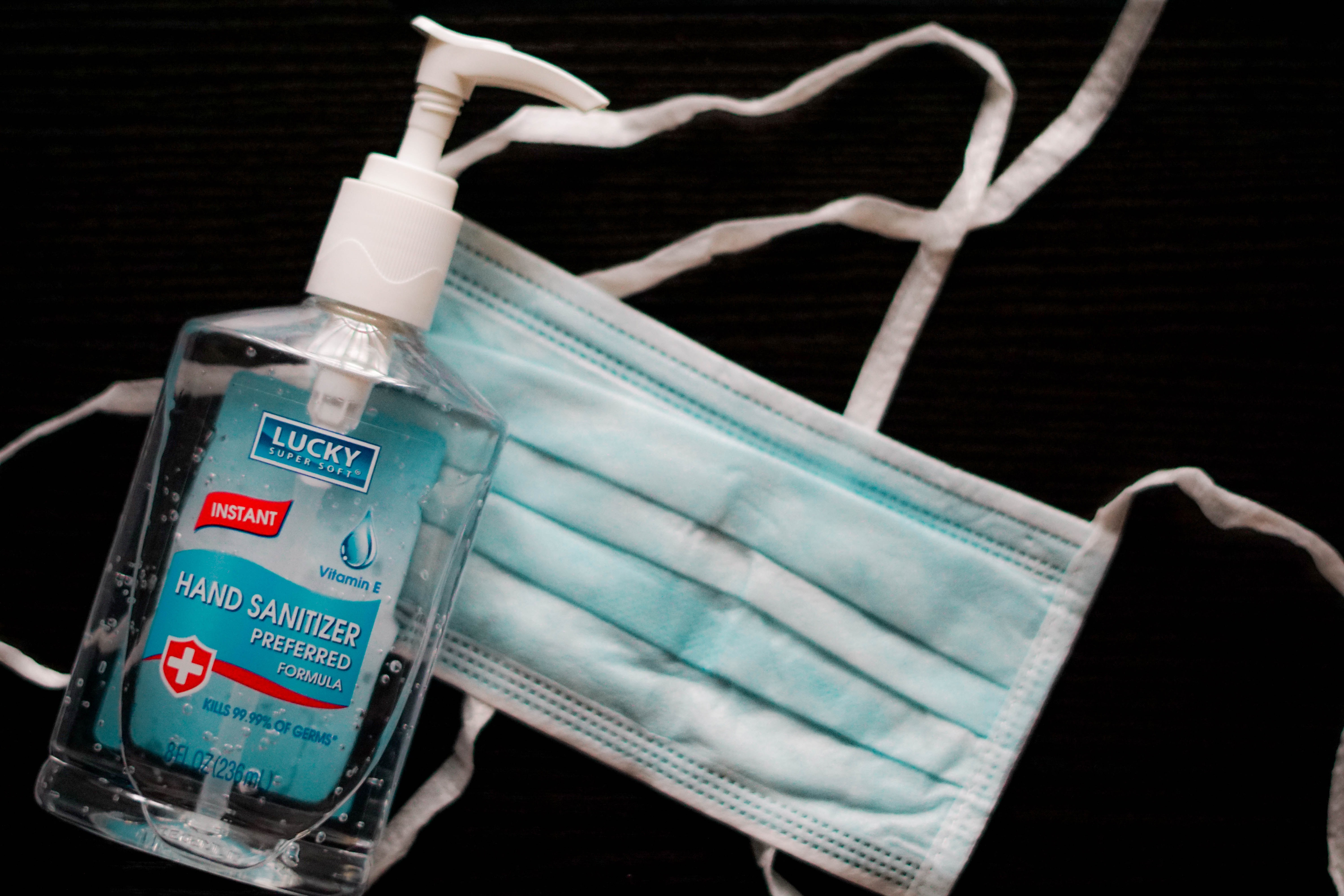 A closeup view of a protective mask and a bottle of hand sanitizer.